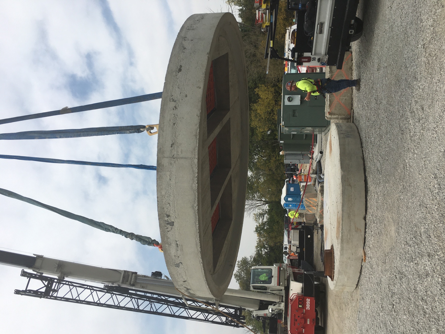 Crane setting a concrete structure at a utility project site