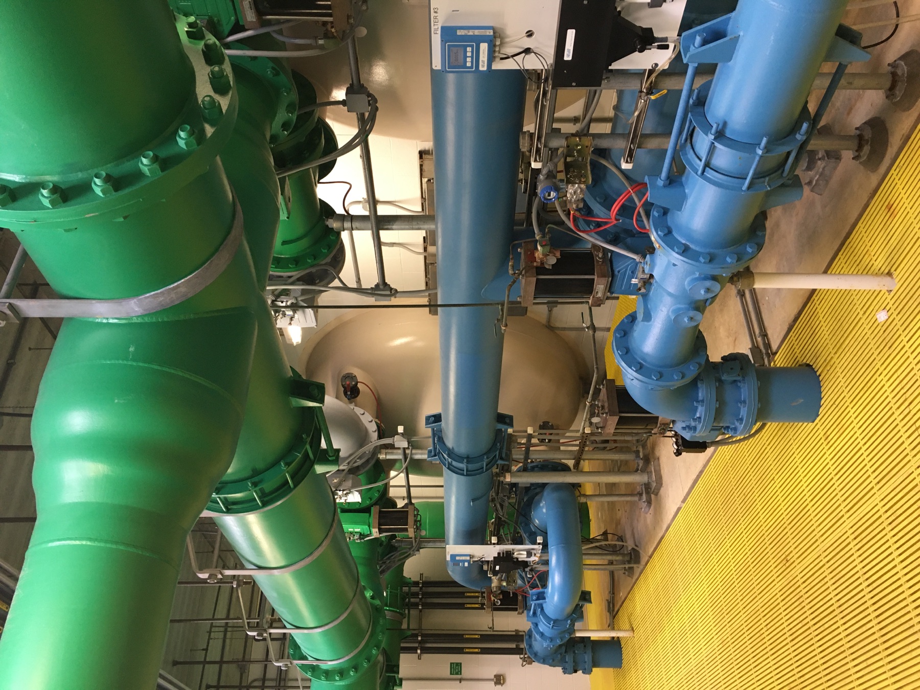 Large green and blue piping inside a water treatment facility
